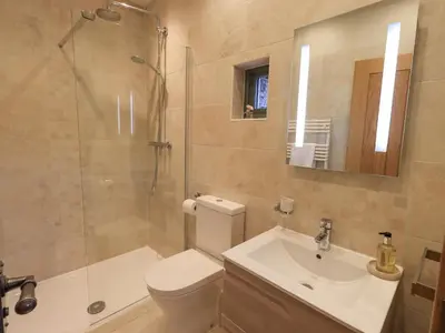 a bathroom with a toilet and a sink and a shower at Keepers Cottage in Ulverston