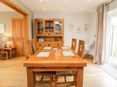 a dining room with a wooden table and chairs at Primrose Cottage in Ulverston