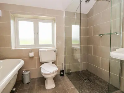 a bathroom with a toilet and a glass shower at Primrose Cottage in Ulverston