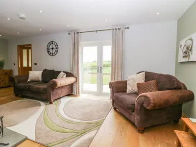 a living room with two chairs and a couch at Primrose Cottage in Ulverston