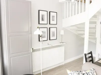 a living room with white walls and white stairs at The Old Post Office in Garstang