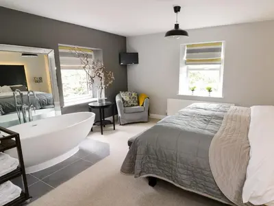 a bedroom with a large bed and a bath tub at The Old Post Office in Garstang
