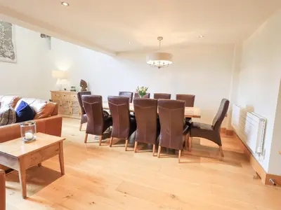 a living room with a dining room table and chairs at Oak Cottage in Ulverston