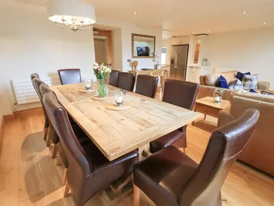 a dining room with a wooden table and leather chairs at Oak Cottage in Ulverston