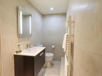 a bathroom with a sink and a toilet and a mirror at Oak Cottage in Ulverston