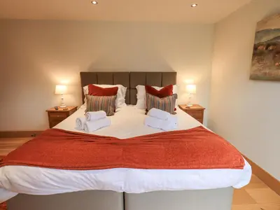 a bedroom with a large bed with two lamps at Oak Cottage in Ulverston