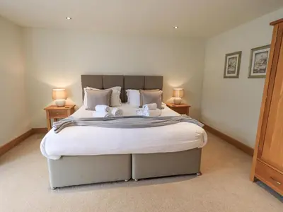 a bedroom with a large bed with two lamps on tables at Oak Cottage in Ulverston