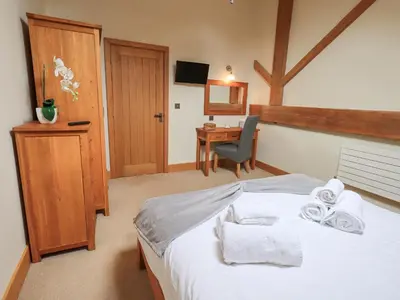 a bedroom with a bed with towels and a desk at Oak Cottage in Ulverston