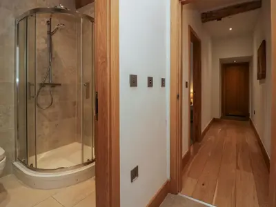 a walk in shower in a bathroom with a toilet at Rowan Cottage in Ulverston
