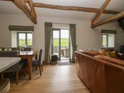 a living room with a couch and a table at Rowan Cottage in Ulverston