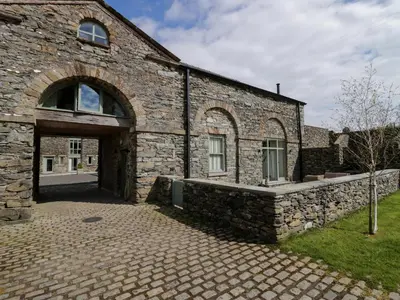 an old stone building with a large door at Rowan Cottage in Ulverston