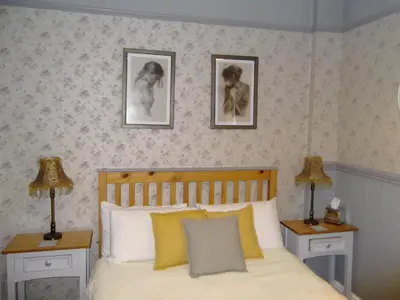 a bedroom with a bed with two night stands and two lamps at J's Mayfair Guest House in Blackpool