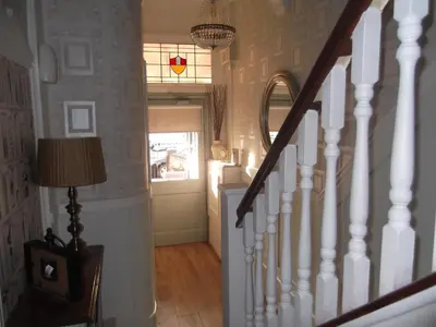 a hallway with a staircase with a door and a lamp at J's Mayfair Guest House in Blackpool