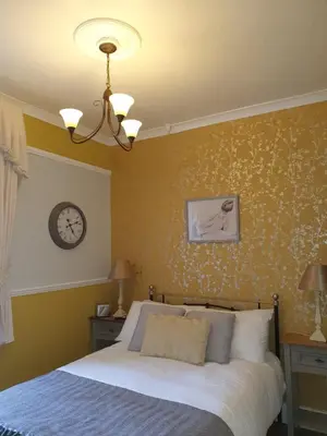 a bedroom with a bed and a clock on the wall at J's Mayfair Guest House in Blackpool