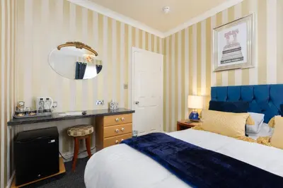 a bedroom with a bed and a sink and a mirror at Adelaide Lodge - Town Centre - Opposite Winter Gardens in Blackpool