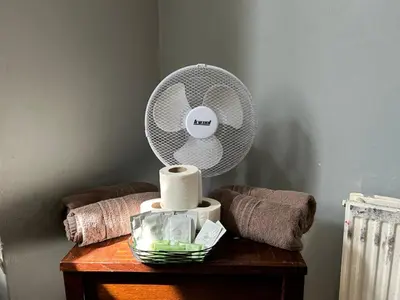 a white fan sitting on top of a table at The Merlin Hotel in Blackpool