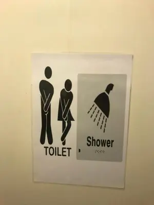 a sign on a bathroom door with a man and a woman at The Merlin Hotel in Blackpool