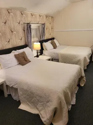 a hotel room with two beds and a lamp at Talbot House in Blackpool