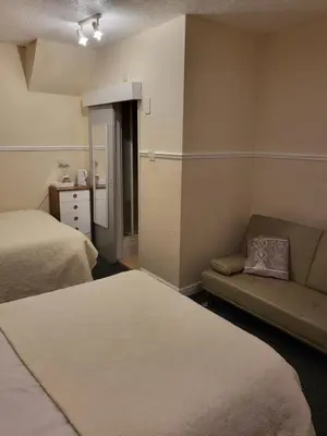 a small room with two beds and a couch at Talbot House in Blackpool
