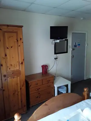 a bedroom with a bed and a dresser and a television at Talbot House in Blackpool