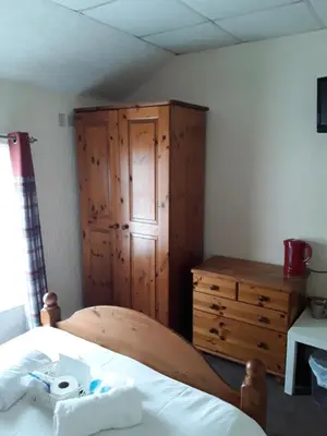 a bedroom with a wooden cabinet and a bed at Talbot House in Blackpool