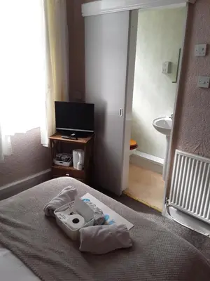 a room with a bed with a sink and a television at Talbot House in Blackpool