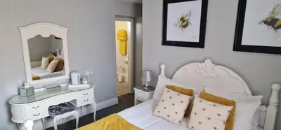 a bedroom with a white bed and a mirror at Hawthorn House in Blackpool
