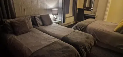 a hotel room with two beds and a couch at Hawthorn House in Blackpool