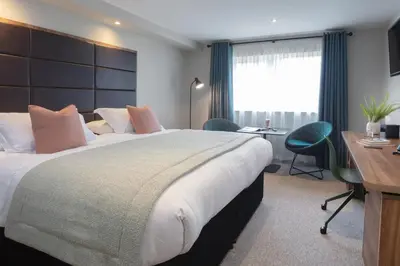 a hotel room with a large bed and a desk at Mytton Fold Hotel, Ribble Valley in Langho