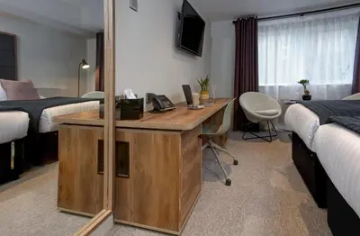 a hotel room with a desk in a bedroom at Mytton Fold Hotel, Ribble Valley in Langho