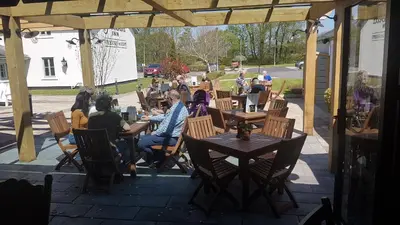 a group of people sitting at tables on a patio at The Bluebird Inn at Samlesbury in Preston