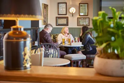 a group of people sitting at a table in a restaurant at The Bluebird Inn at Samlesbury in Preston