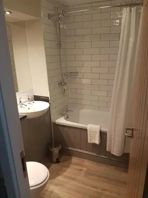a bathroom with a tub and a toilet and a sink at The Bluebird Inn at Samlesbury in Preston