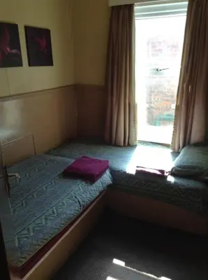 a small bed in a room with a window at Victoria Hotel Blackpool in Blackpool
