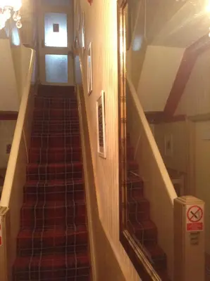 a staircase in a house with a red carpet at Victoria Hotel Blackpool in Blackpool
