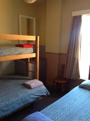 a bedroom with two bunk beds and a window at Victoria Hotel Blackpool in Blackpool