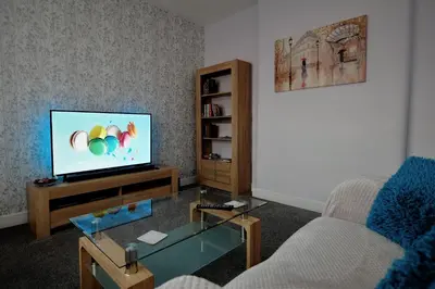 a living room with a television and a table at The Blackpool Apartment in Blackpool