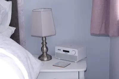 a bedside table with a lamp and a radio on it at The Blackpool Apartment in Blackpool
