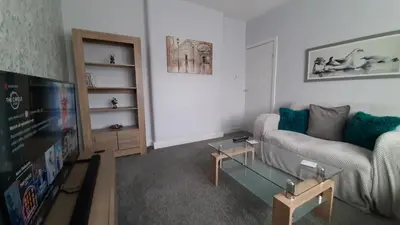 a living room with a couch and a tv at The Blackpool Apartment in Blackpool