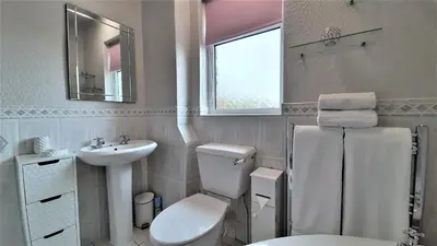 a white bathroom with a toilet and a sink at The Blackpool Apartment in Blackpool