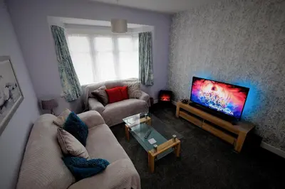 a living room with two couches and a flat screen tv at The Blackpool Apartment in Blackpool