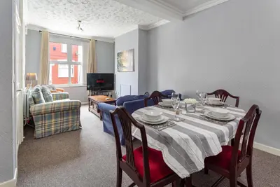 a dining room with a table and a couch at 44 Stonehill Street in Liverpool