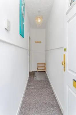 an empty hallway with a door and a chandelier at 44 Stonehill Street in Liverpool