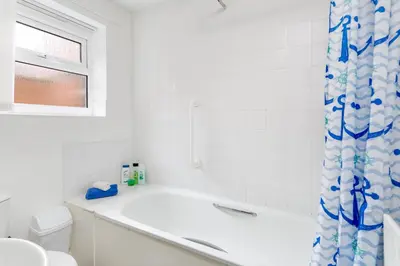a white bathroom with a tub and a toilet at 44 Stonehill Street in Liverpool