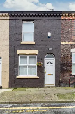 a black brick house with a white door at 44 Stonehill Street in Liverpool