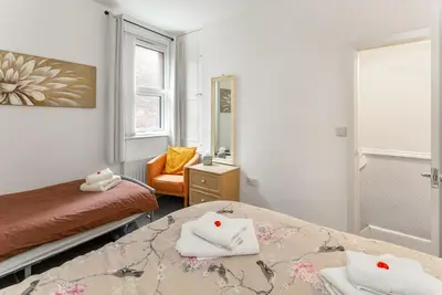 a bedroom with two beds and a mirror at 44 Stonehill Street in Liverpool
