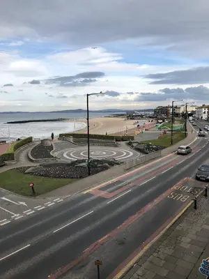 an empty street with a road next to the beach at Morecambe sea view apartment 203 in Morecambe