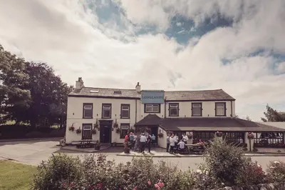 a group of people standing outside of a white building at Longlands Inn & Cottages in Carnforth