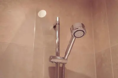 a shower with a shower head in a bathroom at Longlands Inn & Cottages in Carnforth