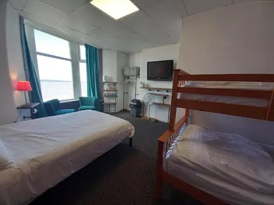 a hotel room with two beds and a television at Vinnie's Family Hotel in Blackpool